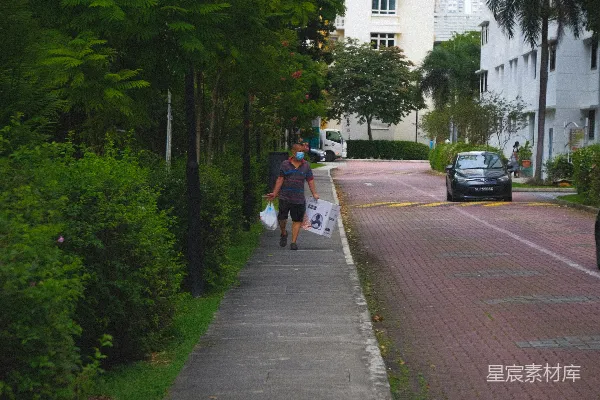 高清摄影 一个人在人行道上遛狗