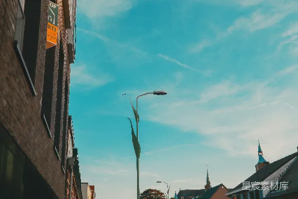 高清摄影 一盏路灯矗立在城市街道旁边，旁边有一栋建筑。