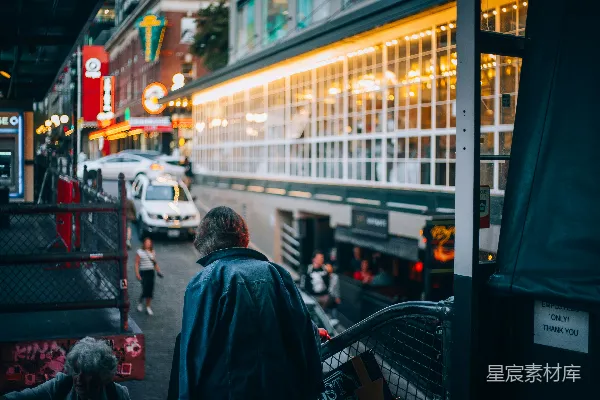 高清摄影 一个男人正沿着一幢高大楼房旁的街道行走。