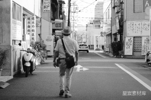 高清摄影 一个背着背包的男人走在街上。