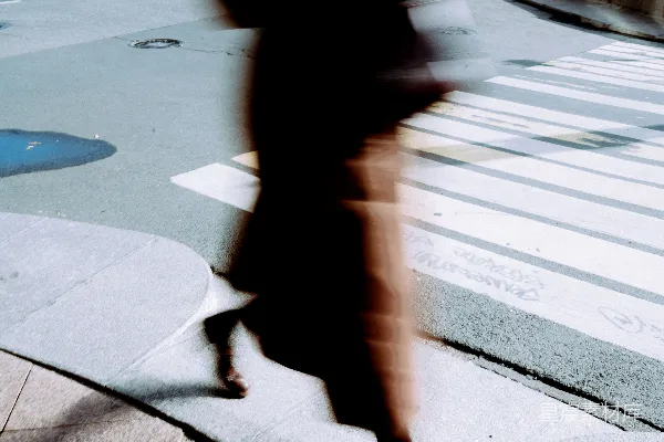 高清摄影 一张模糊的照片，显示一个人正在过马路。