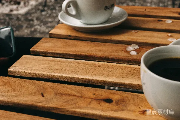 棕色木桌上的白色陶瓷茶杯