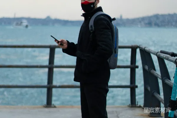 黑色夹克和裤子的男人站在桥上进行白天的照片