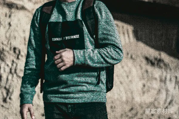 背着背包戴着太阳镜的男人站在山前