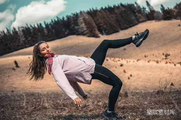 白衬衫长袖女子在白天的褐色草地上跳着黑色长裤。