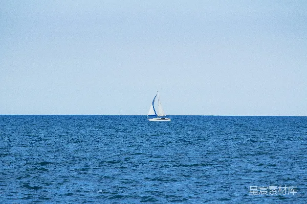 高清摄影 白天，海洋中央有一艘白色的帆船。