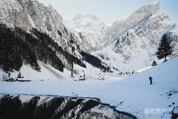远处有一湖，近处是白雪覆盖的山景。