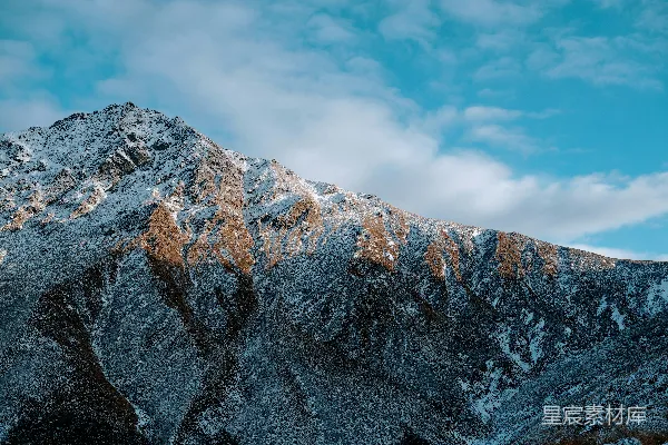 山峰覆盖着白雪，背景是蓝天。
