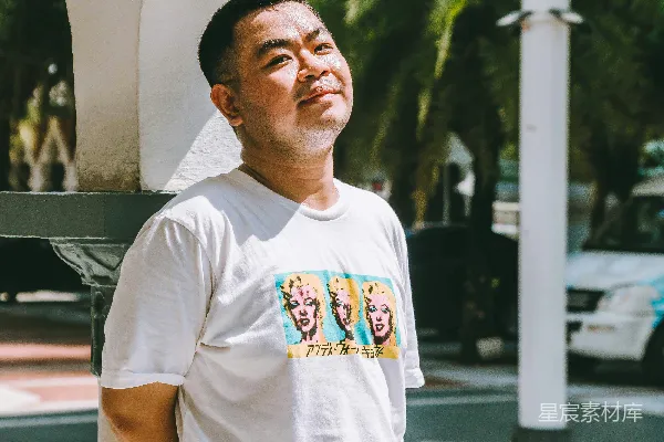 一个男人站在一个巨大的苹果雕塑前