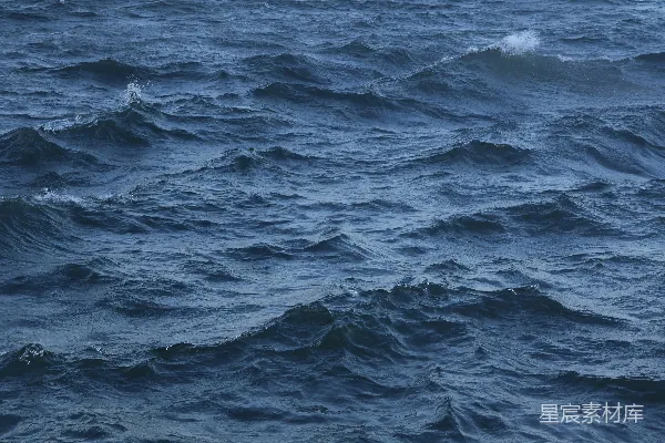 波光粼粼的蓝色海浪在波涛汹涌的大海上起伏。