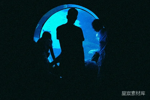 高清摄影 一个男人和一个女人站在蓝色灯光前的剪影。
