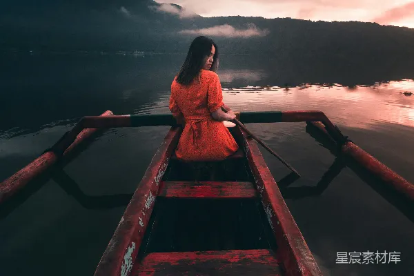 身穿红衣的女人在棕色木制码头上白天坐着