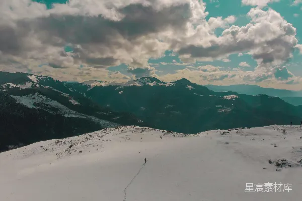 白天云遮山雪覆盖的山脉