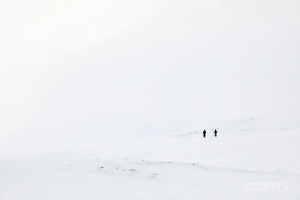 高清摄影 几个人正穿过一片积雪覆盖的田野。