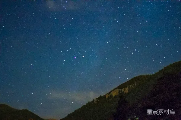 夜空繁星点点，山峰在上方。