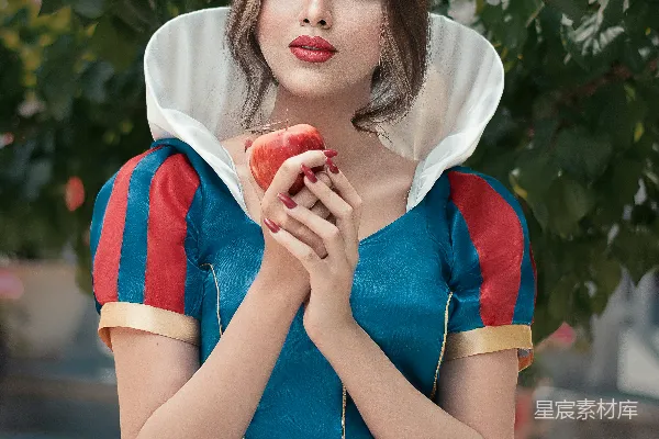 高清摄影 穿红色和白色圆领T恤的女性手里拿着一个红苹果。