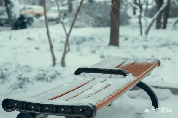 公园里一排覆盖着白雪的木制长椅