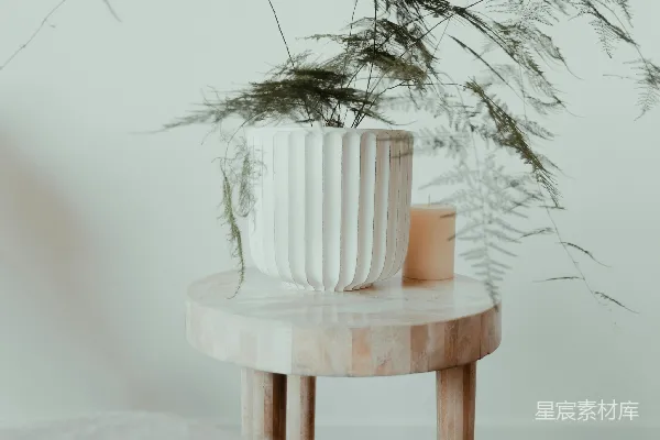 高清摄影 一个白色的花瓶放在一张木制桌子上。