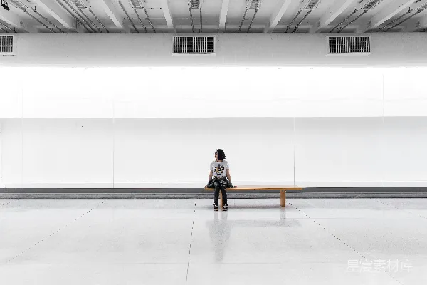 高清摄影 一个女人坐在大房间的长椅上。