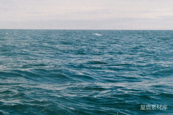 深蓝海洋波涛 beneath 乌云密布的天空