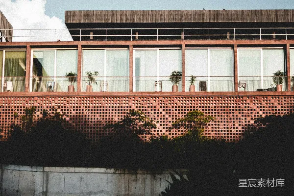 前面有一栋用红砖砌成的建筑，旁边有棕榈树。