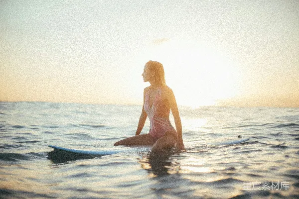女性在水中骑着一块蓝色的冲浪板