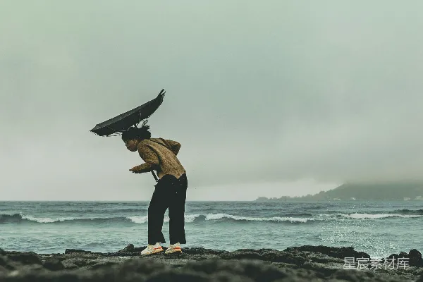 沙滩上站着一个人，头上有一只鸟。