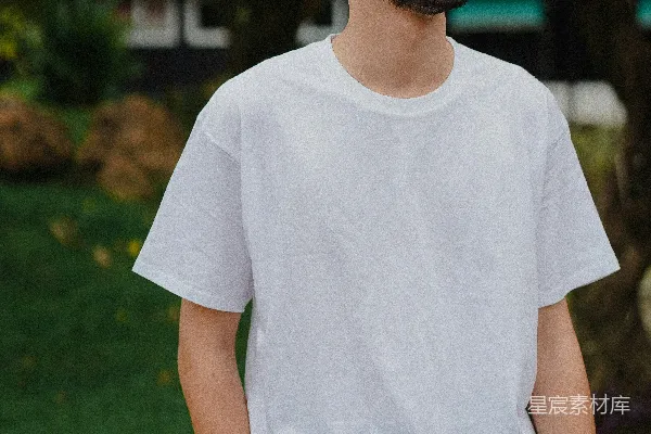 高清摄影 穿白色圆领T恤的男人站在白天的绿色草地上。