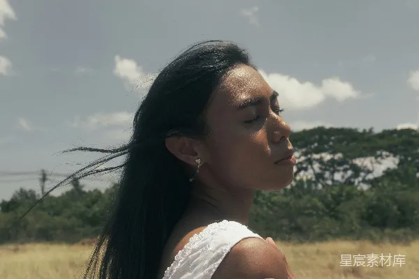 一头长发的女子站在田野中