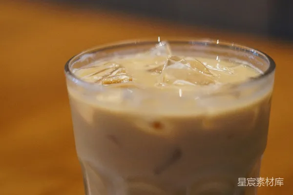 一杯加了奶精的冰咖啡，高脚杯大小。