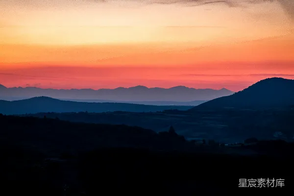 高清摄影 夕阳正缓缓落下，映照在连绵的山脉之上。