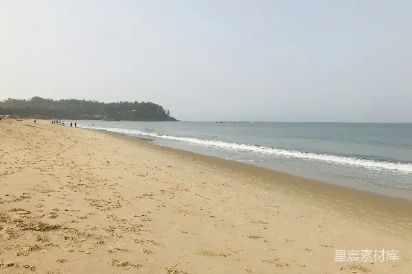 一片沙子覆盖的海滩，海浪拍打着它。