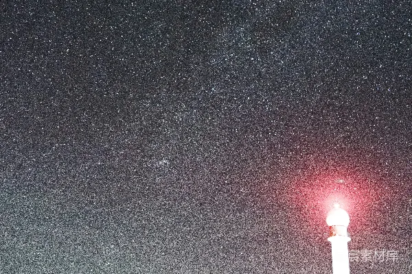 黑夜中停在红绿灯附近的黑色汽车，夜空下星光点点。
