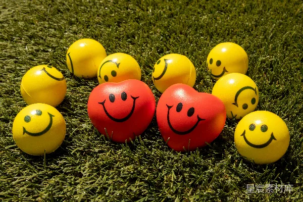 绿色草地上的红色黄色笑脸emoji