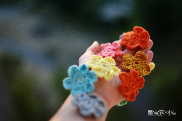 一只手拿着一束钩编的花朵
