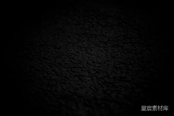 高清摄影 一个深色、有纹理的表面，光线柔和。