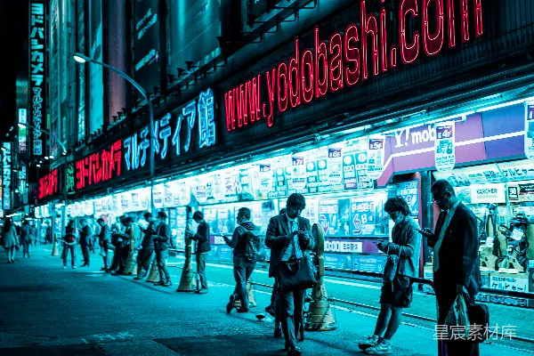 夜幕下人群聚集在亮灯的建筑物旁