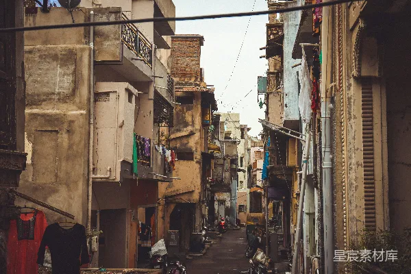 一条狭窄的城市街道两旁是建筑和人。