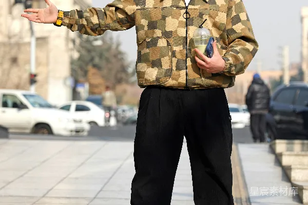 身穿迷彩夹克和黑色裤子的人拿着饮料