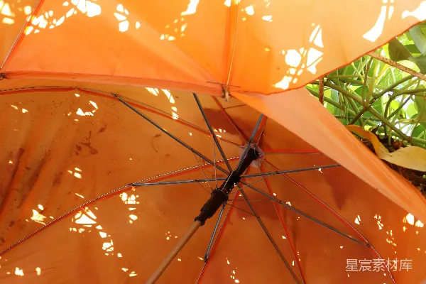 高清摄影 橙色的雨伞上有一个洞，可以透光。