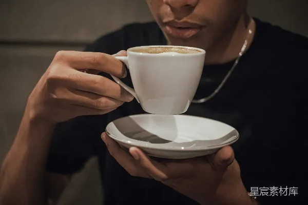 一个男人拿着一杯咖啡。