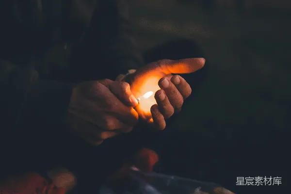 夜间有人手持点燃的蜡烛
