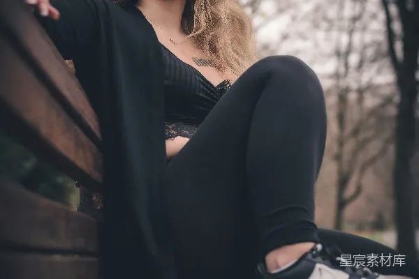 一个女人坐在一张木制长凳上。