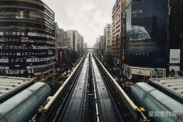 一列火车穿行于城市的旁边，旁边是高大的建筑物