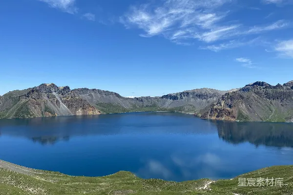 一片被山峦环绕的蓝色湖泊，蓝天作背景。