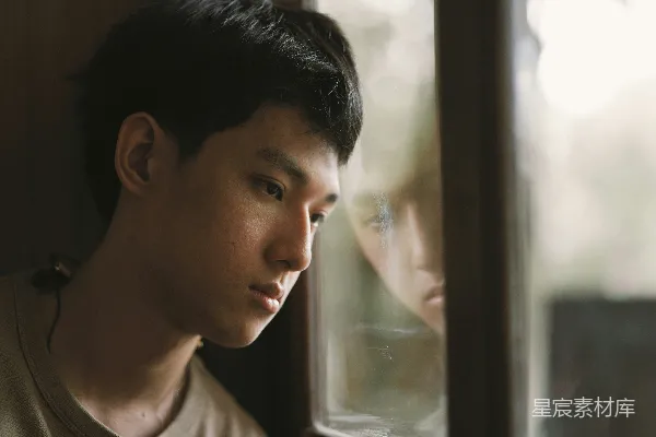 一个男人站在窗前看着另一个人。