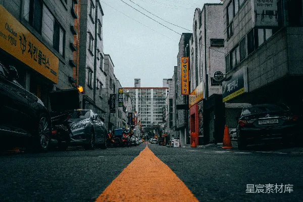 高清摄影 白天，建筑物之间路边停着的汽车。