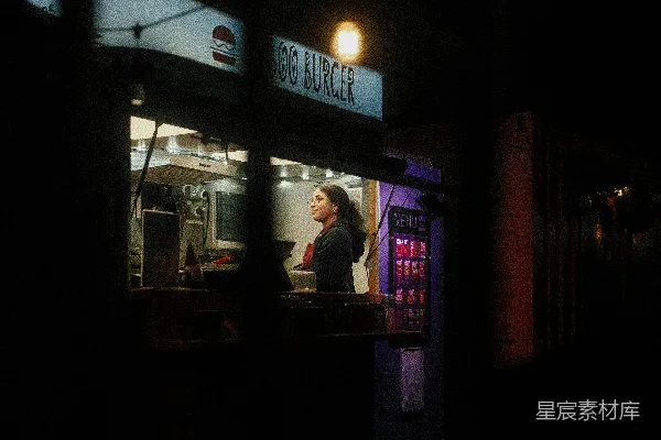 夜晚妇女在一家流动餐馆工作。