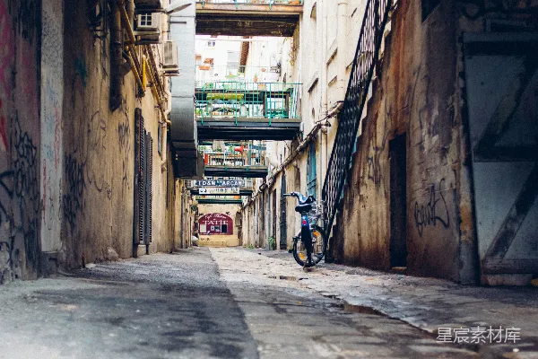 黑色自行车白天停在棕色混凝土建筑旁边。