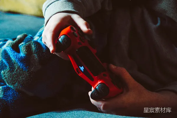 手持红色PlayStation 4控制器的人